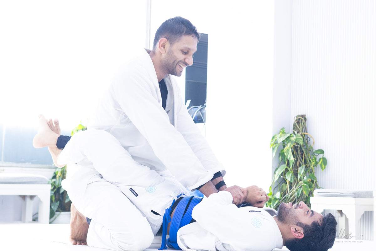 Instructor helping a student up during training — kindness in action at Knots & Collar