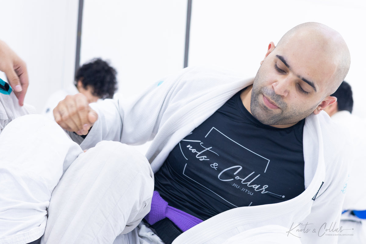 Purple belt BJJ practitioner drilling collar control technique