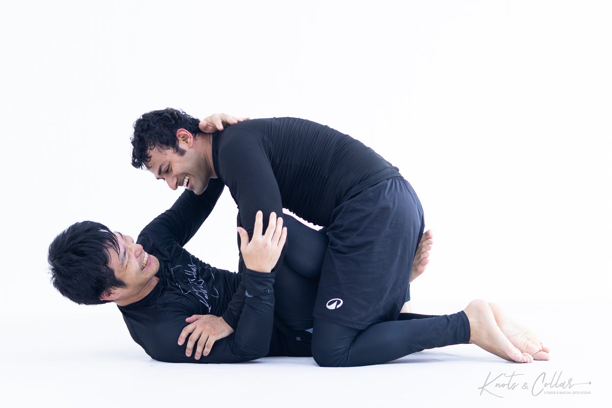 BJJ practitioners rolling with technical intent while caring for their training partner's safety