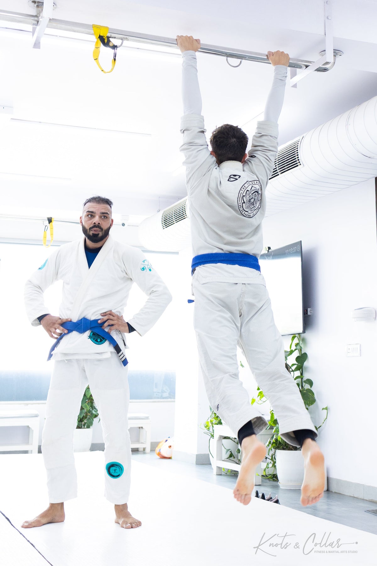 BJJ practitioner doing pull-ups as part of strength and conditioning training