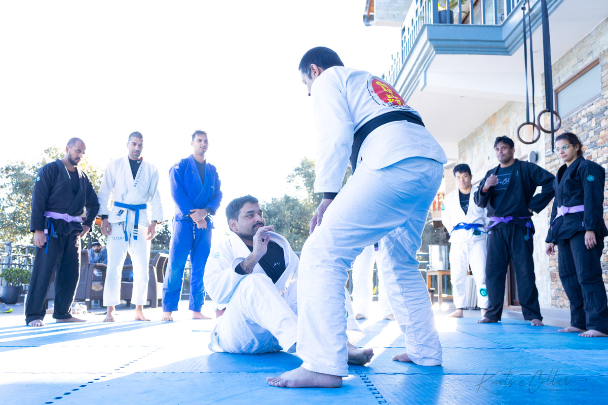Instructor demonstrating a BJJ technique to students at KC Manthan 2025 retreat