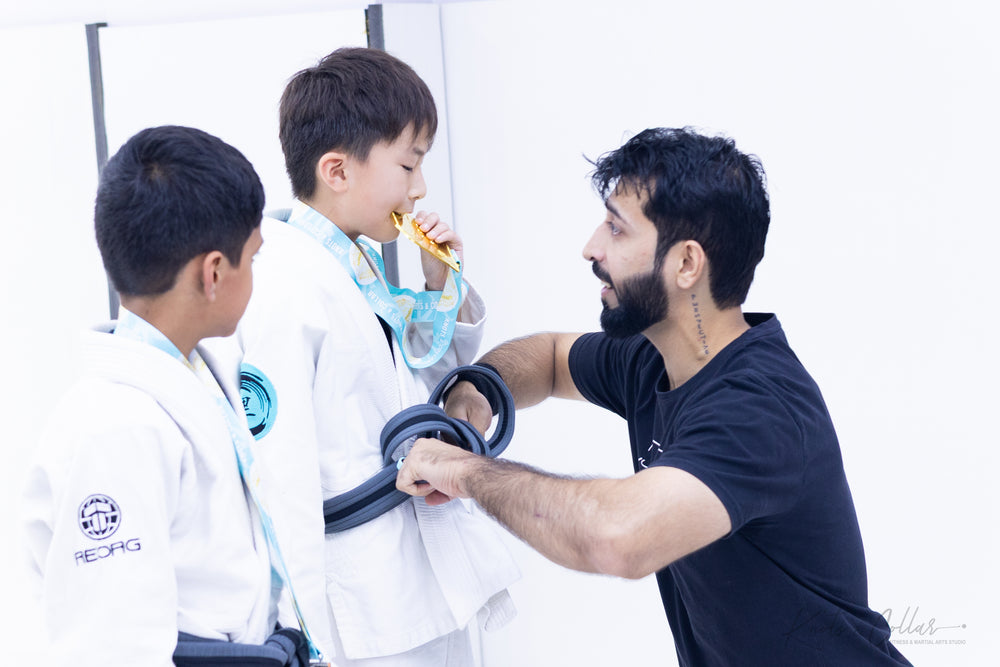 Professor Binish Sukhija awarding medals and bjj belts to kids at Knots and Collar BJJ class Defence Colony Delhi