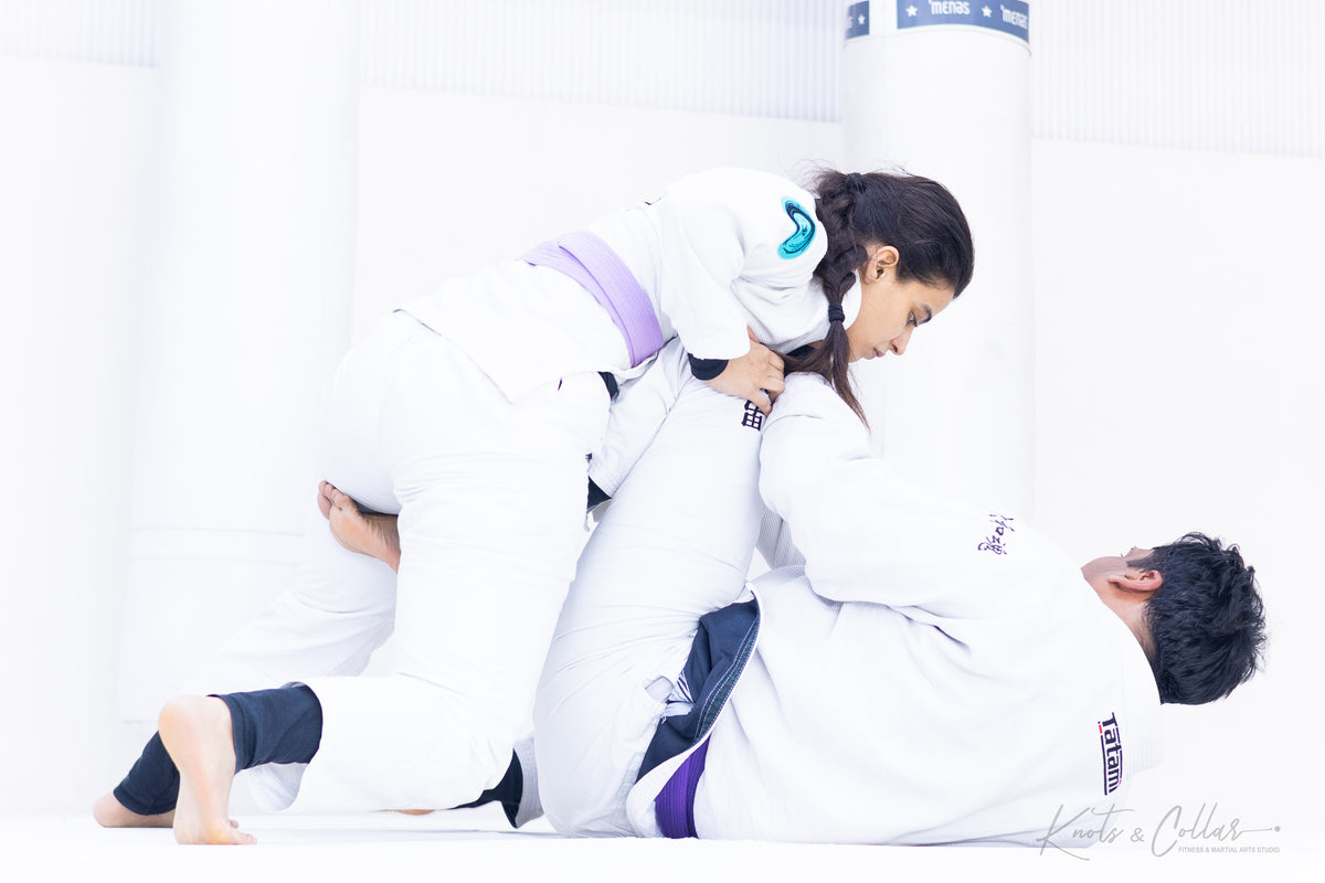 Woman executing BJJ guard pass in gi at Knots and Collar Defence Colony New Delhi